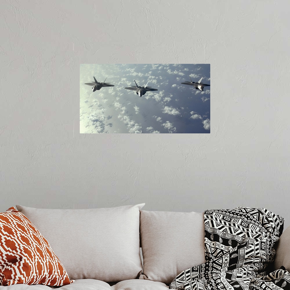 A bohemian room featuring A threeship formation of F22 Raptors fly over the Pacific Ocean