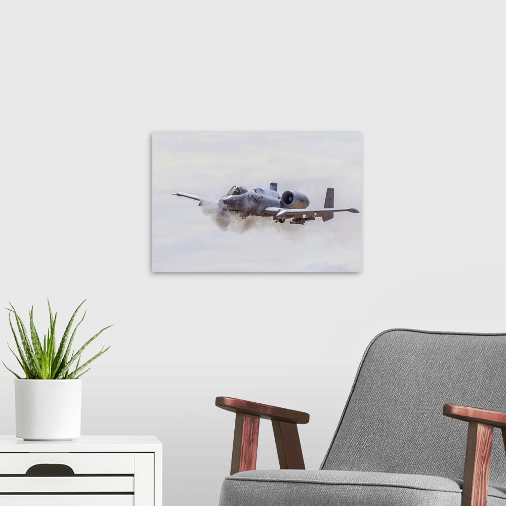 A modern room featuring A U.S. Air Force A-10 Thunderbolt II fires its 30mm cannon on a low level strafe run at the Barry...