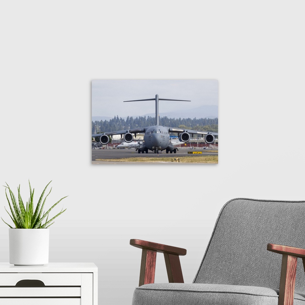 A modern room featuring A U.S. Air Force C-17 Globemaster III taxis in after landing at Portland International Airport, O...