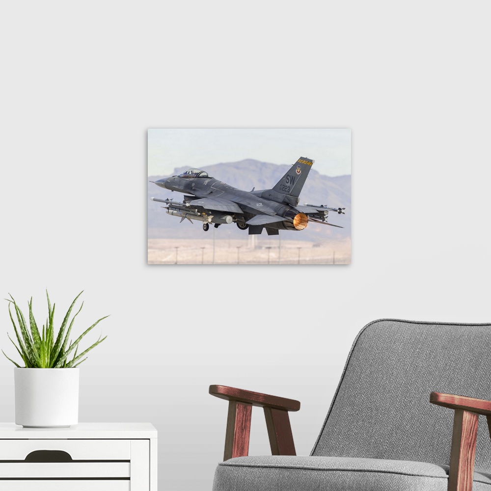 A modern room featuring A U.S. Air Force F-16C Fighting Falcon turns after taking off from Nellis Air Force Base, Nevada.