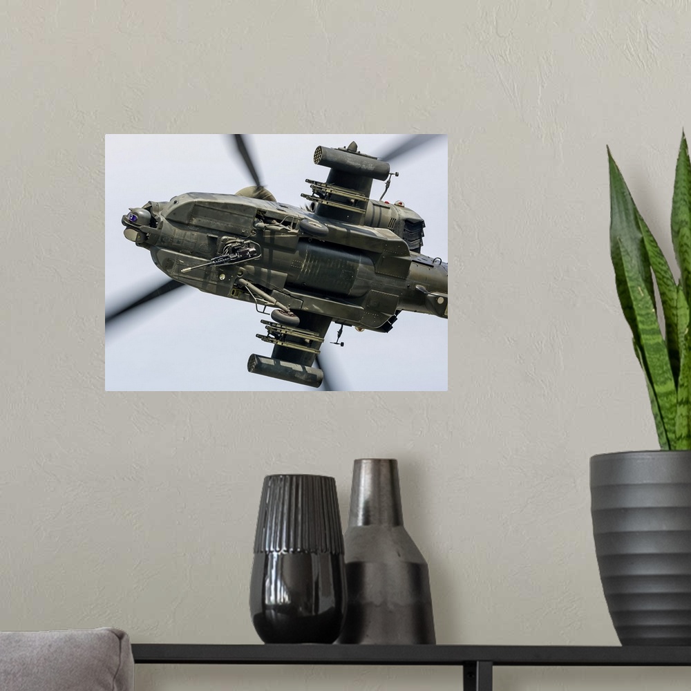 A modern room featuring A U.S. Army AH-64D Apache Longbow pulls into a turn over Cleveland, Ohio.