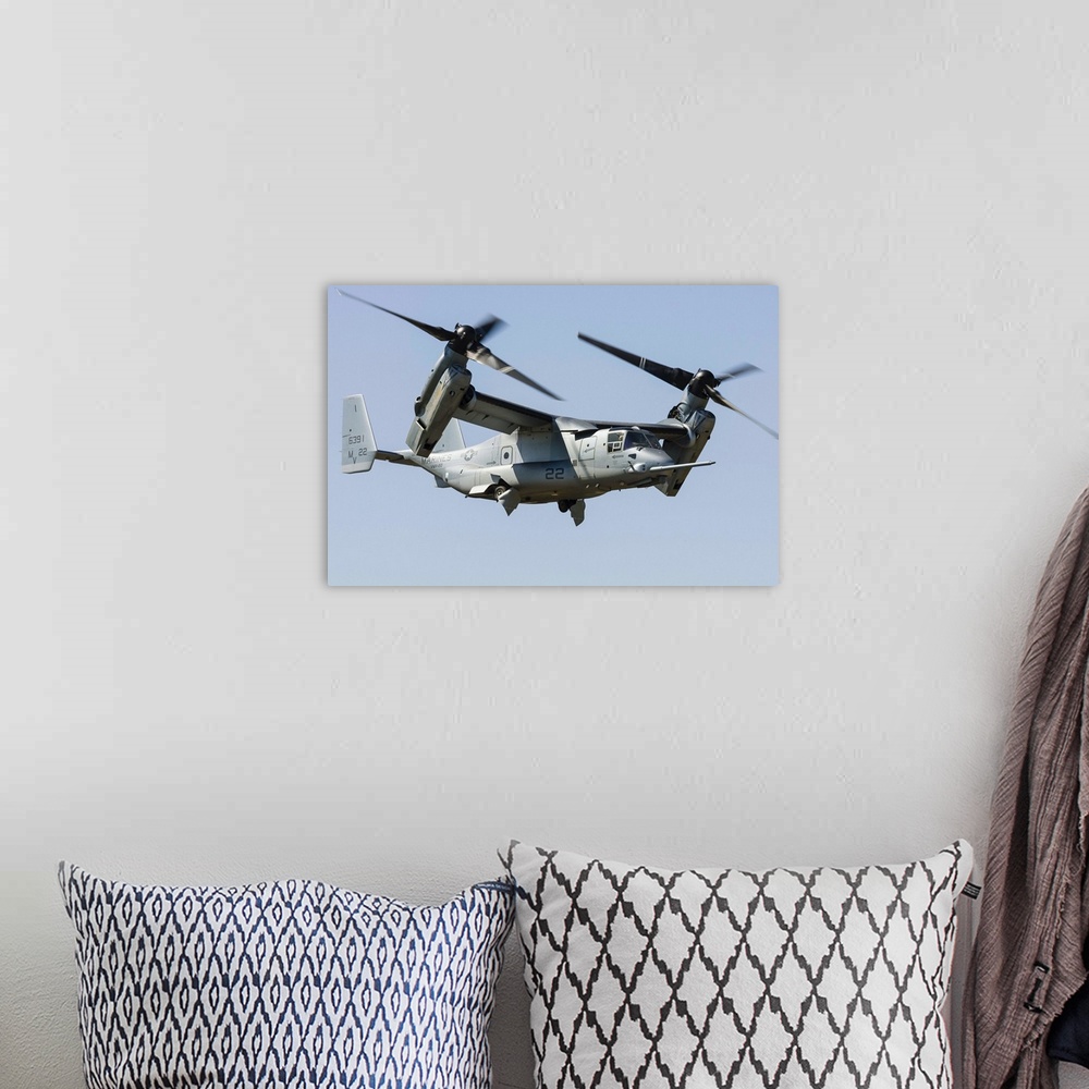 A bohemian room featuring A U.S. Marine Corps V-22 Osprey transitions to wingborne flight at RAF Fairford, England.