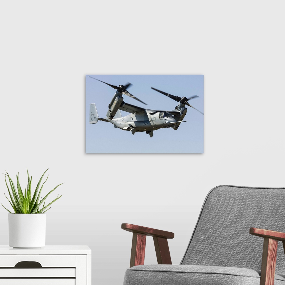A modern room featuring A U.S. Marine Corps V-22 Osprey transitions to wingborne flight at RAF Fairford, England.