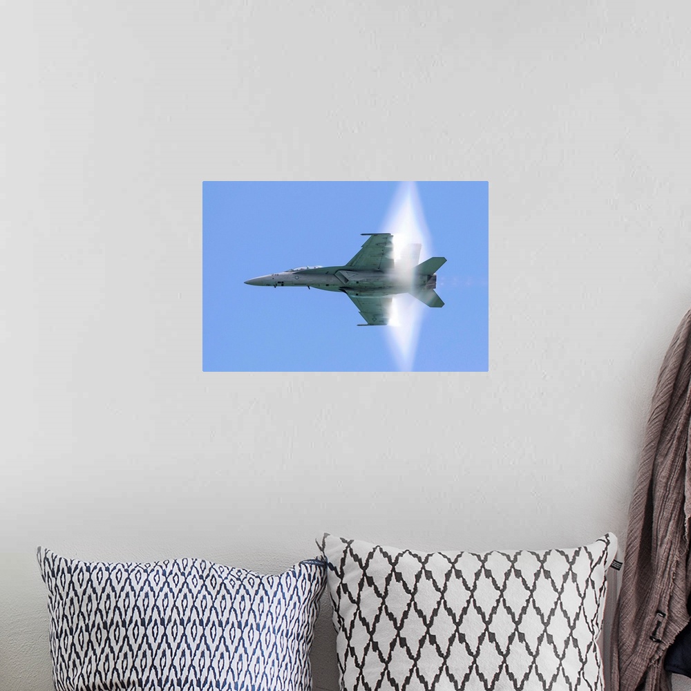 A bohemian room featuring A U.S. Navy F/A-18F Super Hornet flies by at high transonic speed.