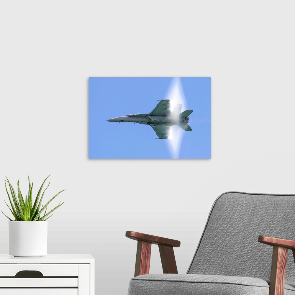 A modern room featuring A U.S. Navy F/A-18F Super Hornet flies by at high transonic speed.