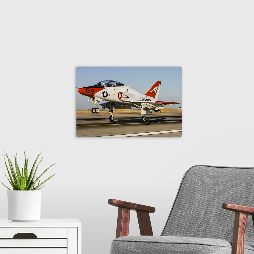 A modern room featuring A U.S. Navy T-45 Goshawk taking off as it practices field carrier landings at Naval Air Station E...