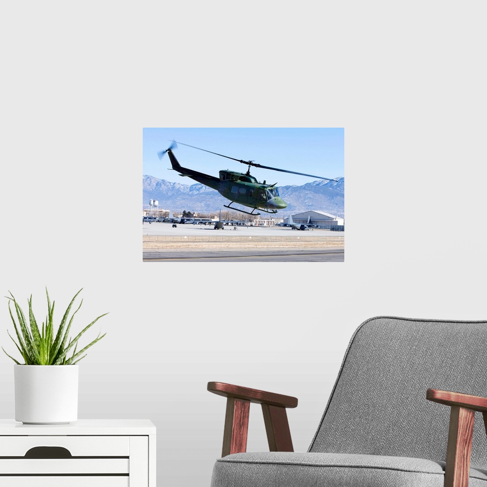 A modern room featuring A UH-1N Twin Huey from the 512th RQS flies a training mission near Kirtland Air Force Base, New M...