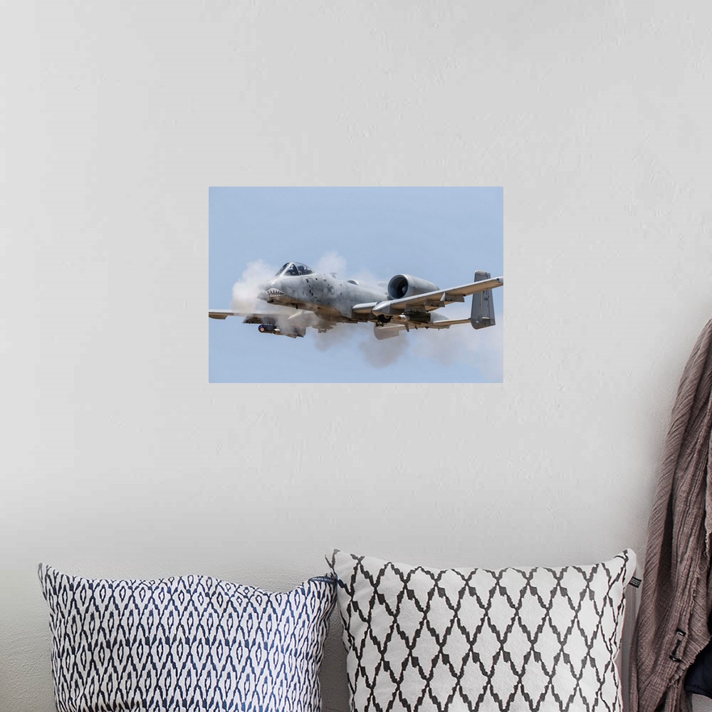 A bohemian room featuring A U.S. Air Force A-10 Thunderbolt II fires its 30mm gun at a strafe target.