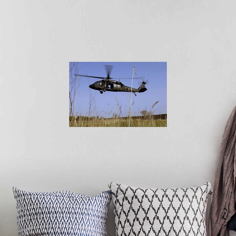 A bohemian room featuring Photograph taken of a helicopter as it lifts off in a tall grass field.