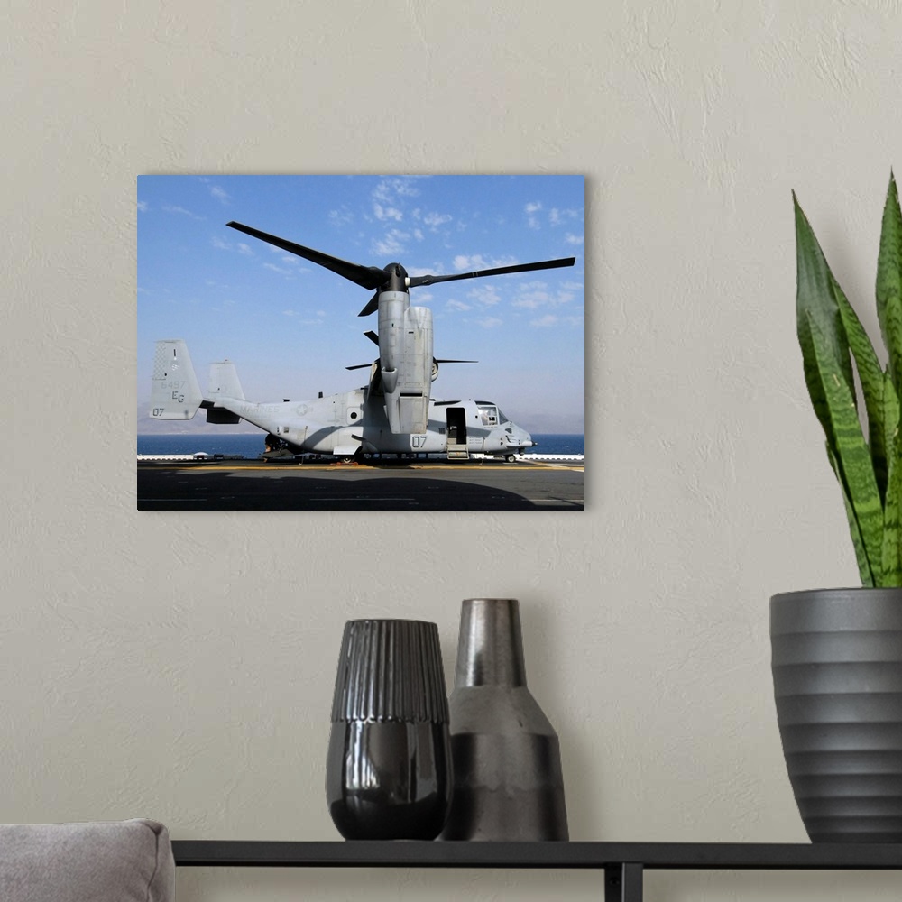 A modern room featuring A U.S. Marine Corps MV-22 Osprey prepares for flight on the deck USS Wasp.