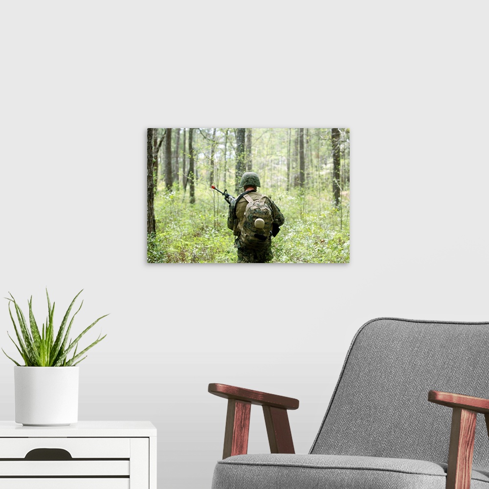 A modern room featuring A U.S. Marine patrols through a forest during a field exercise.