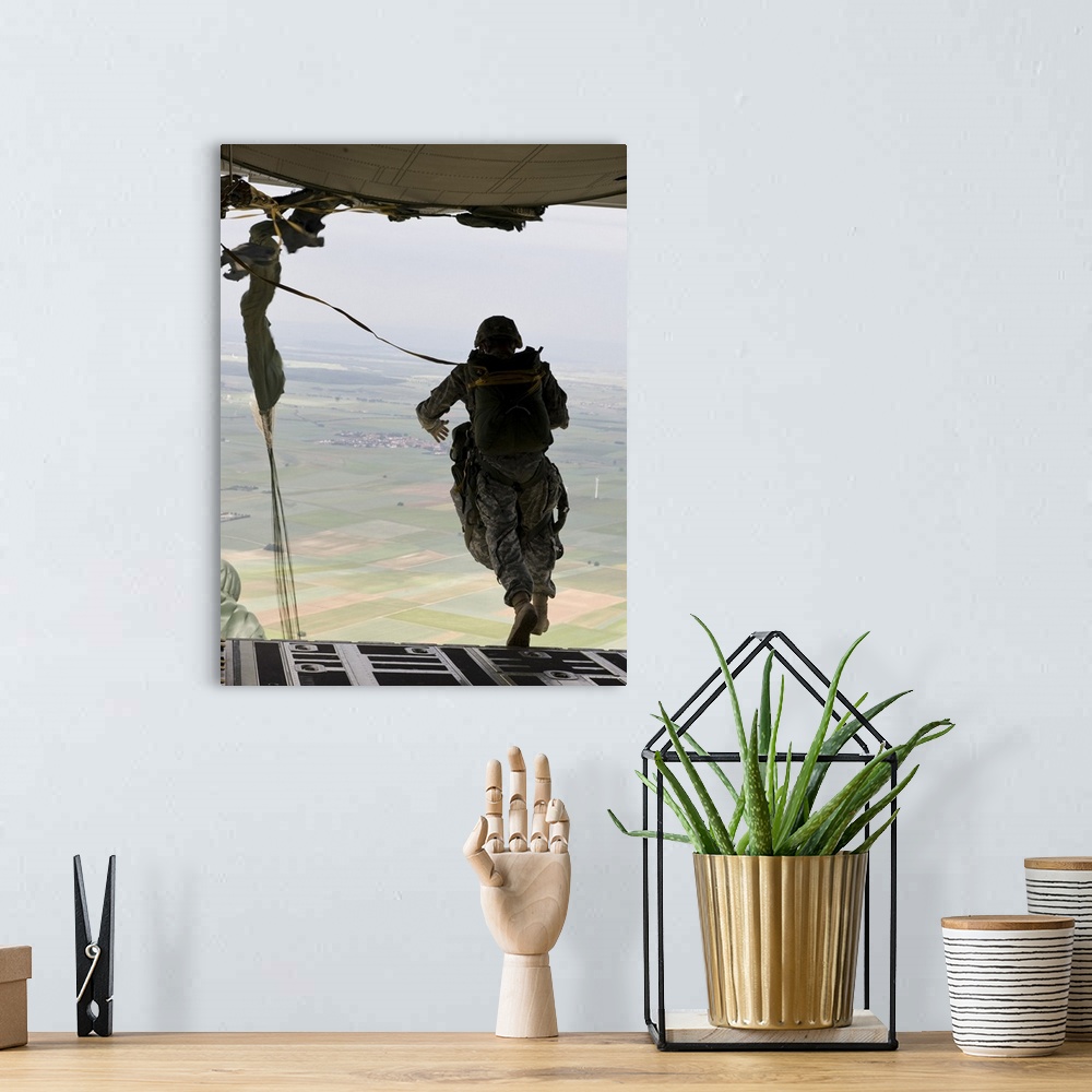 A bohemian room featuring A U.S. soldier jumps out of a C-130J Super Hercules.