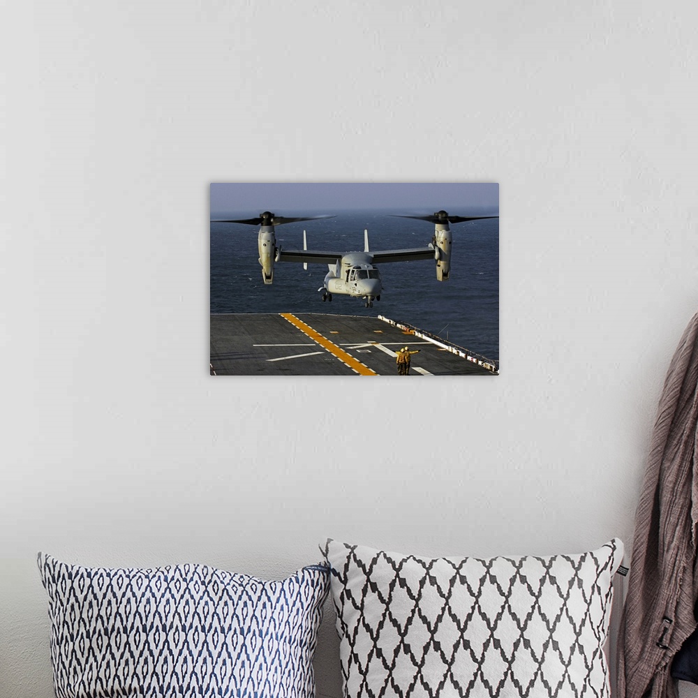 A bohemian room featuring A V22 Osprey aircraft landing on the flight deck the USS Bataan