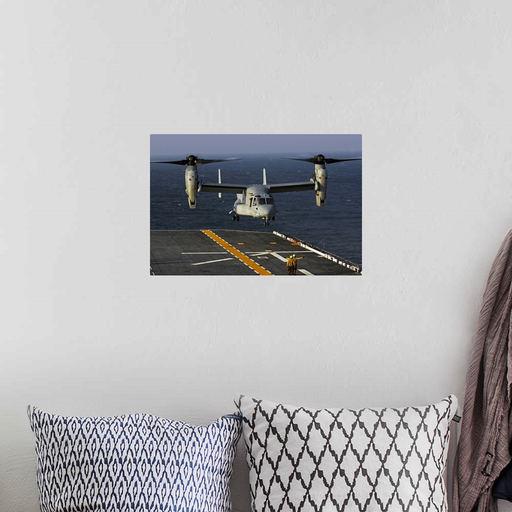 A bohemian room featuring A V22 Osprey aircraft landing on the flight deck the USS Bataan