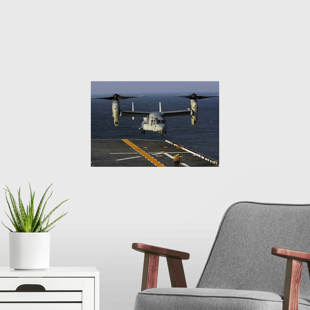A modern room featuring A V22 Osprey aircraft landing on the flight deck the USS Bataan