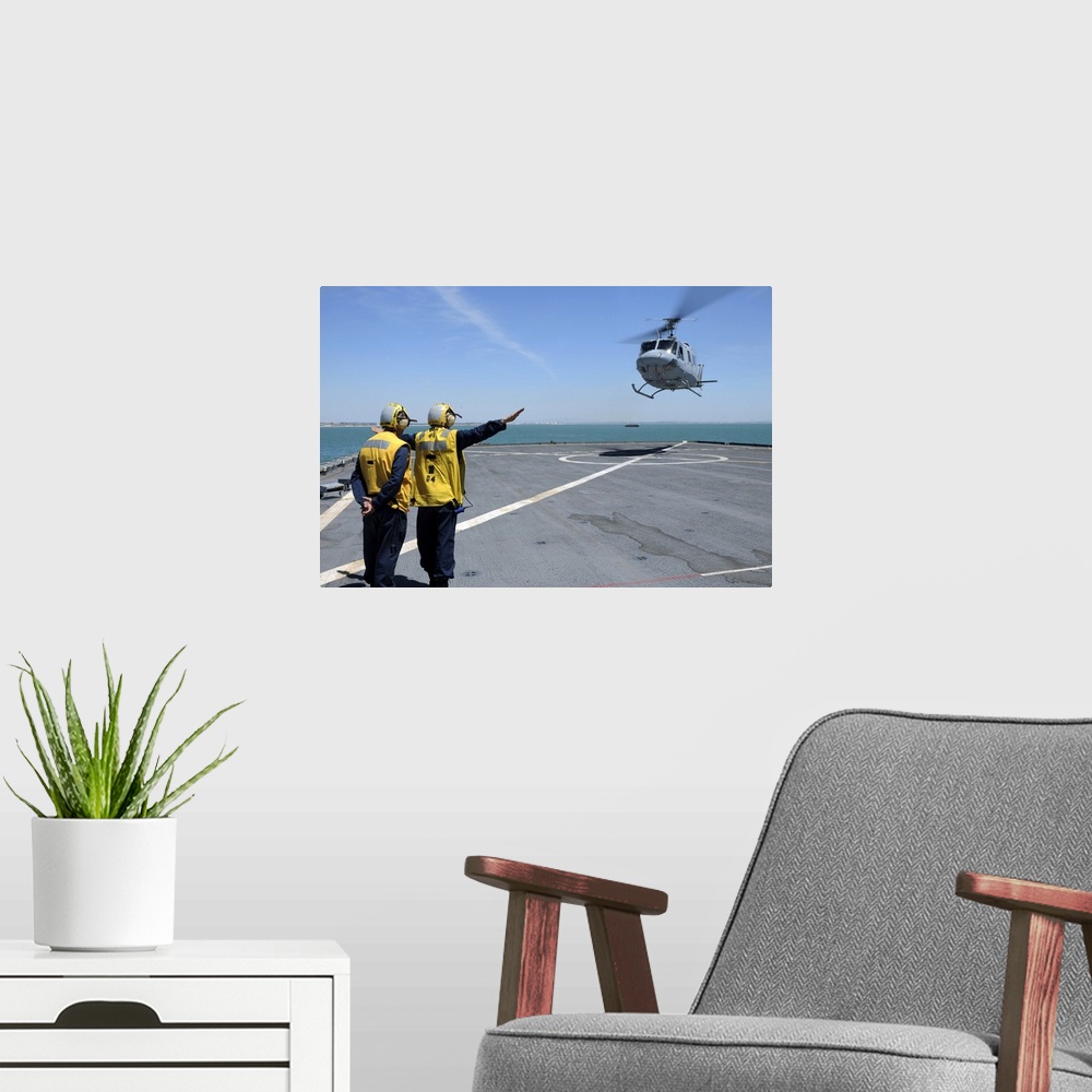 A modern room featuring Atlantic Ocean, May 5, 2010 - Airmen direct a Spanish navy AB-212 helicopter onto the flight deck...