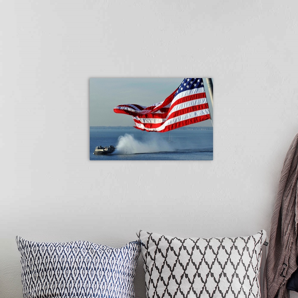 A bohemian room featuring American flag blowing in the wind with a hovercraft in the background.