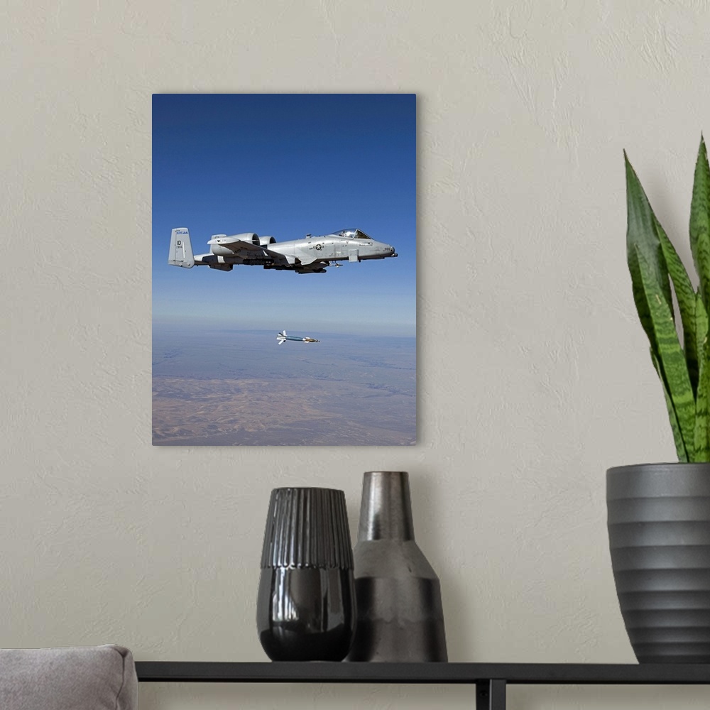 A modern room featuring An A-10C Thunderbolt from the 190th Fighter Squadron releases a GBU-12 Laser Guided Bombs during ...