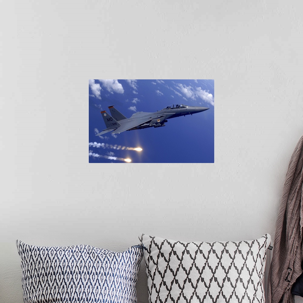 A bohemian room featuring Photograph taken of a military aircraft flying over water as it shoots flares off the Guam coast.