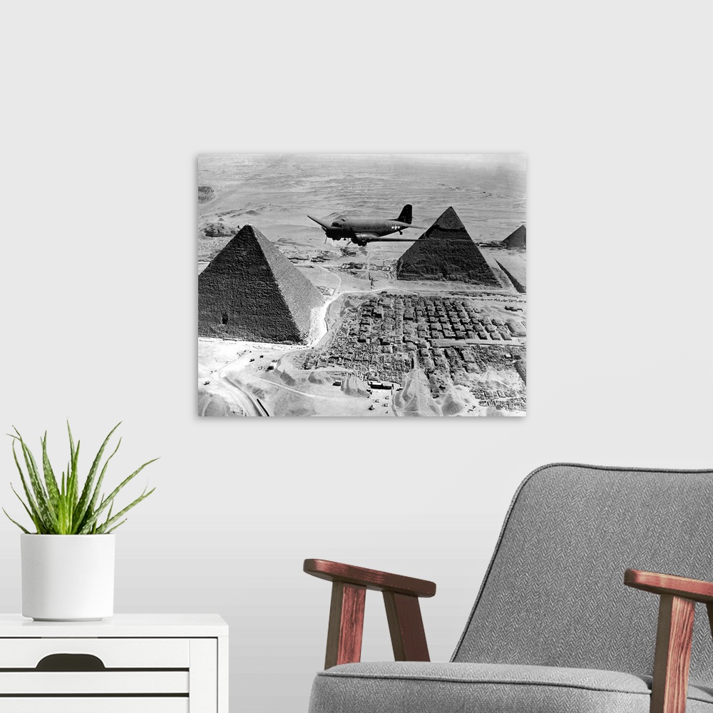 A modern room featuring An Air Transport Command plane flies over the pyramids in Egypt, 1943.