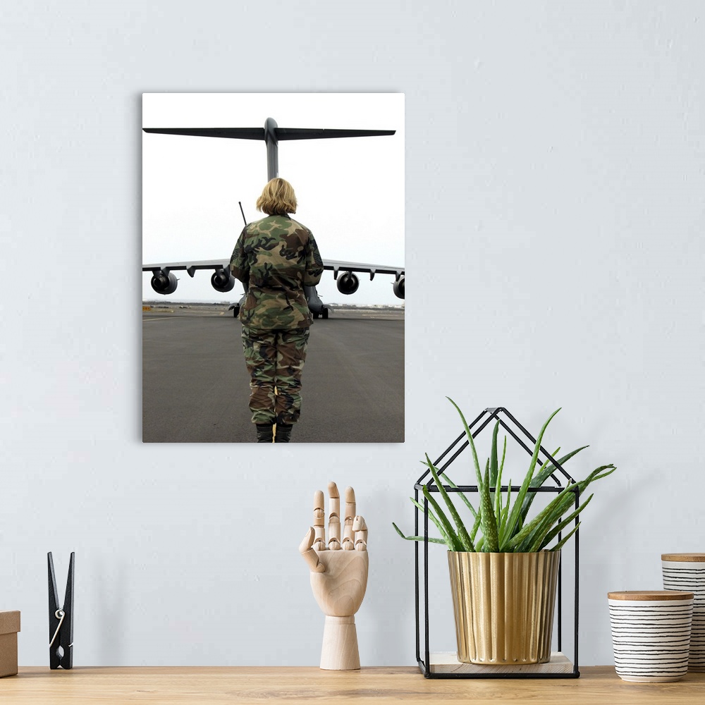 A bohemian room featuring An airfield manager greets an arriving C-17 Globemaster III.