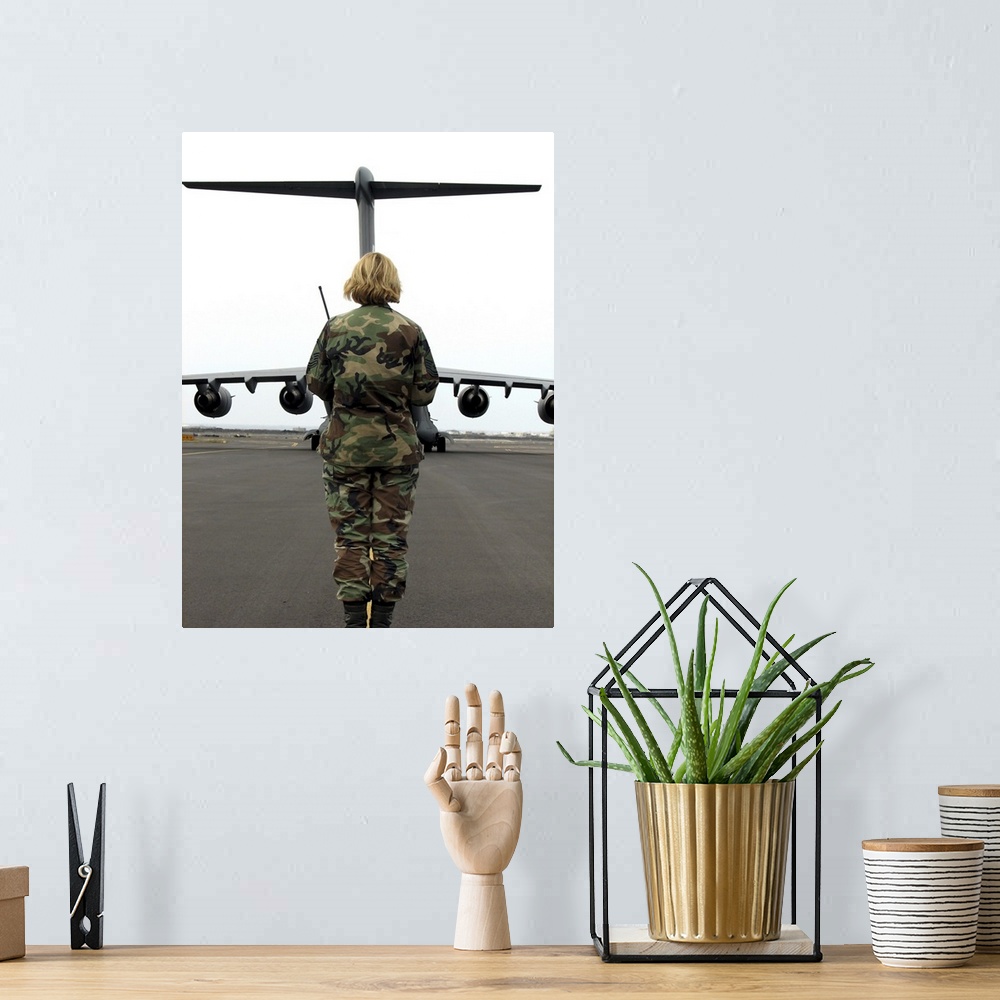 A bohemian room featuring An airfield manager greets an arriving C-17 Globemaster III.