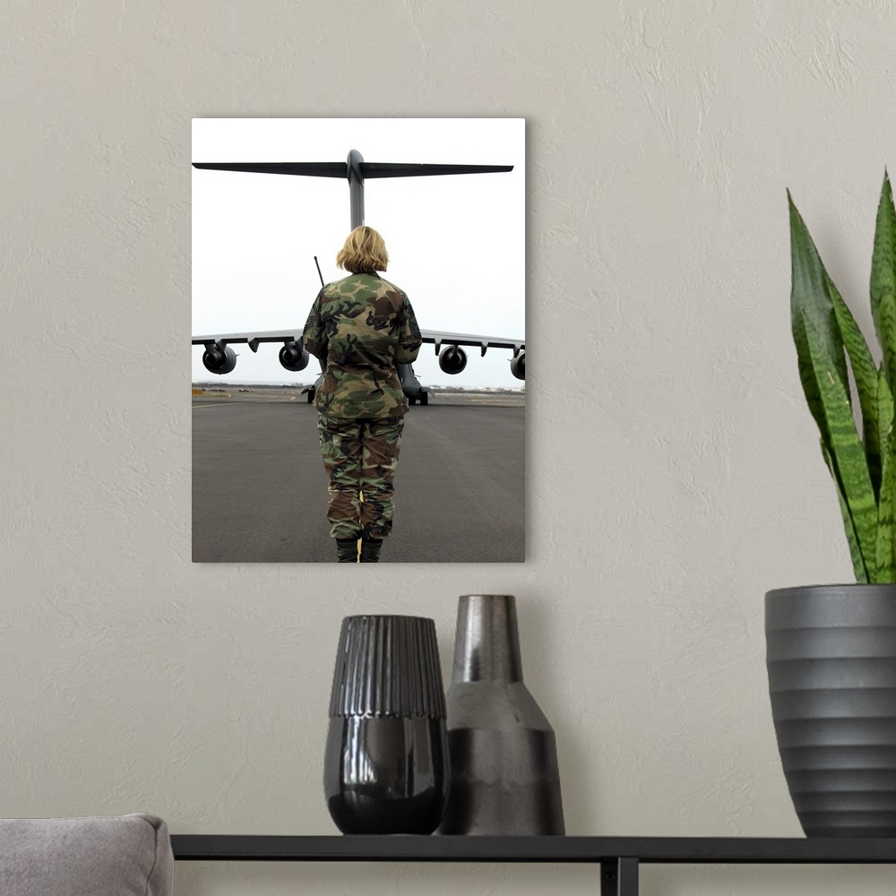 A modern room featuring An airfield manager greets an arriving C-17 Globemaster III.