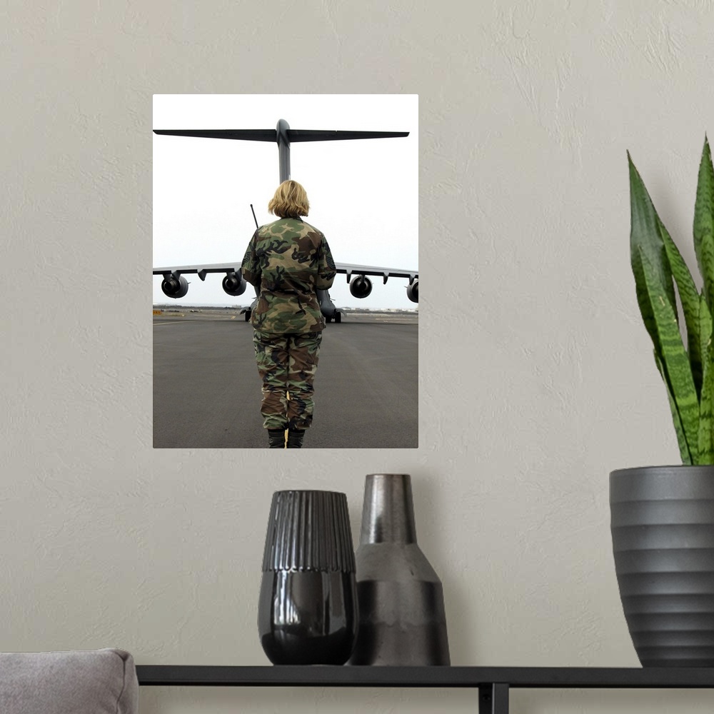 A modern room featuring An airfield manager greets an arriving C-17 Globemaster III.