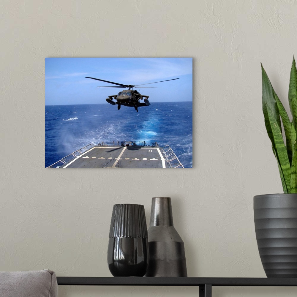 A modern room featuring An Army UH-60 Black Hawk helicopter landing aboard the USS Underwood off the coast of Honduras.