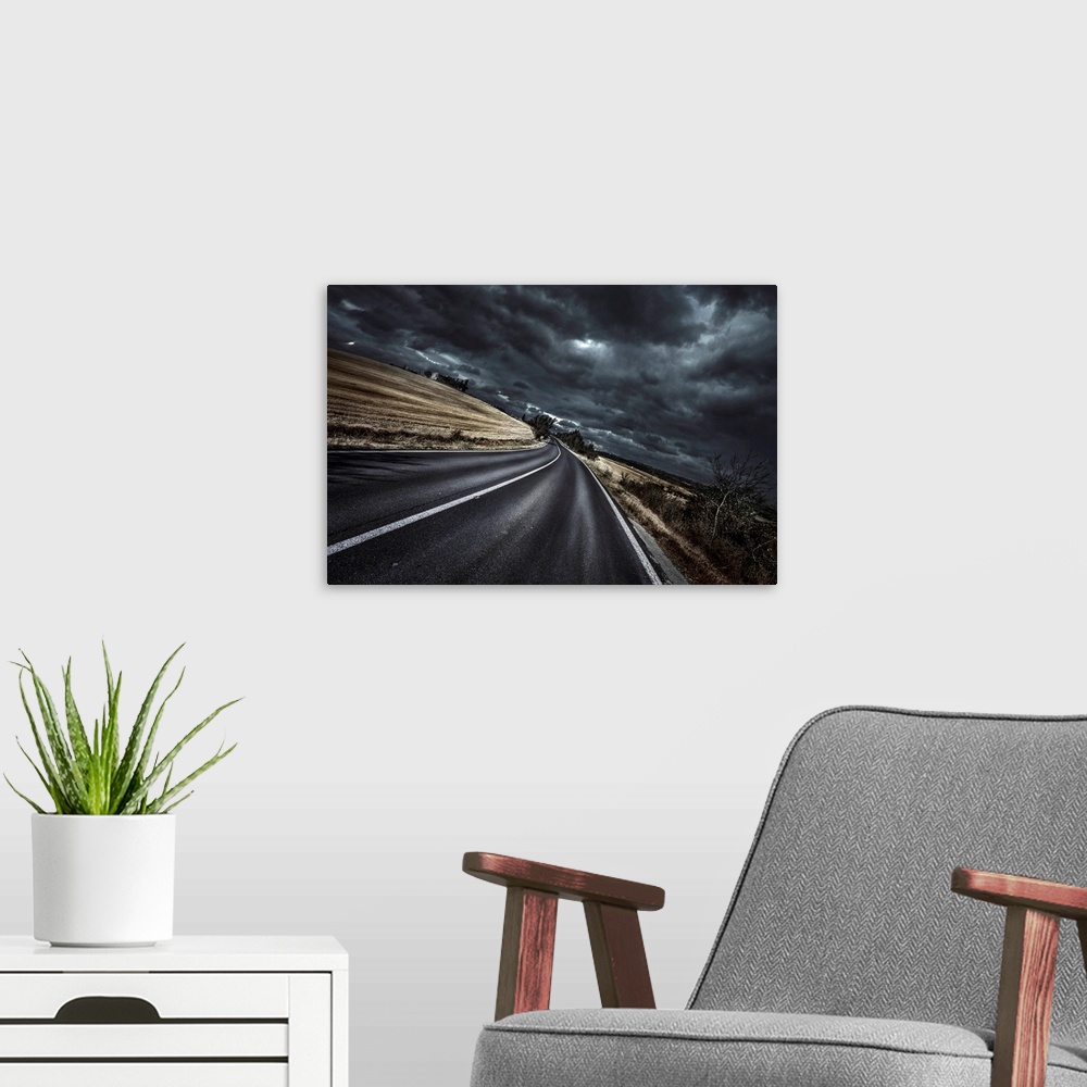 A modern room featuring An asphalt road with stormy sky above, Tuscany, Italy.