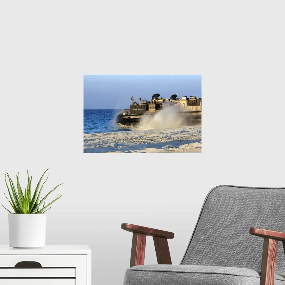 A modern room featuring An assault craft heads back to sea after dropping off cargo during an offload.