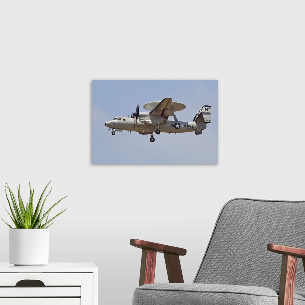 A modern room featuring An E-2D Advanced Hawkeye of the U.S. Navy in flight over the Pacific coast of California.