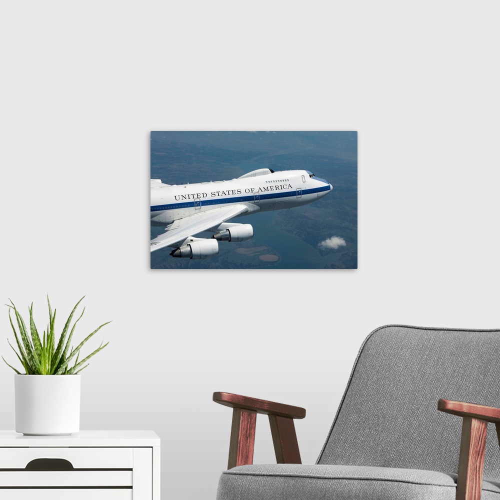 A modern room featuring An E-4B National Airborne Operations Center (NAOC) aircraft flies high over the Midwest on a trai...
