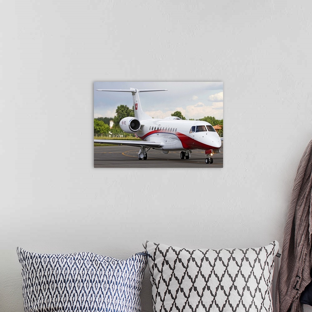 A bohemian room featuring An Embraer Legacy 600 private jet taxiing at Turin Airport, Italy.