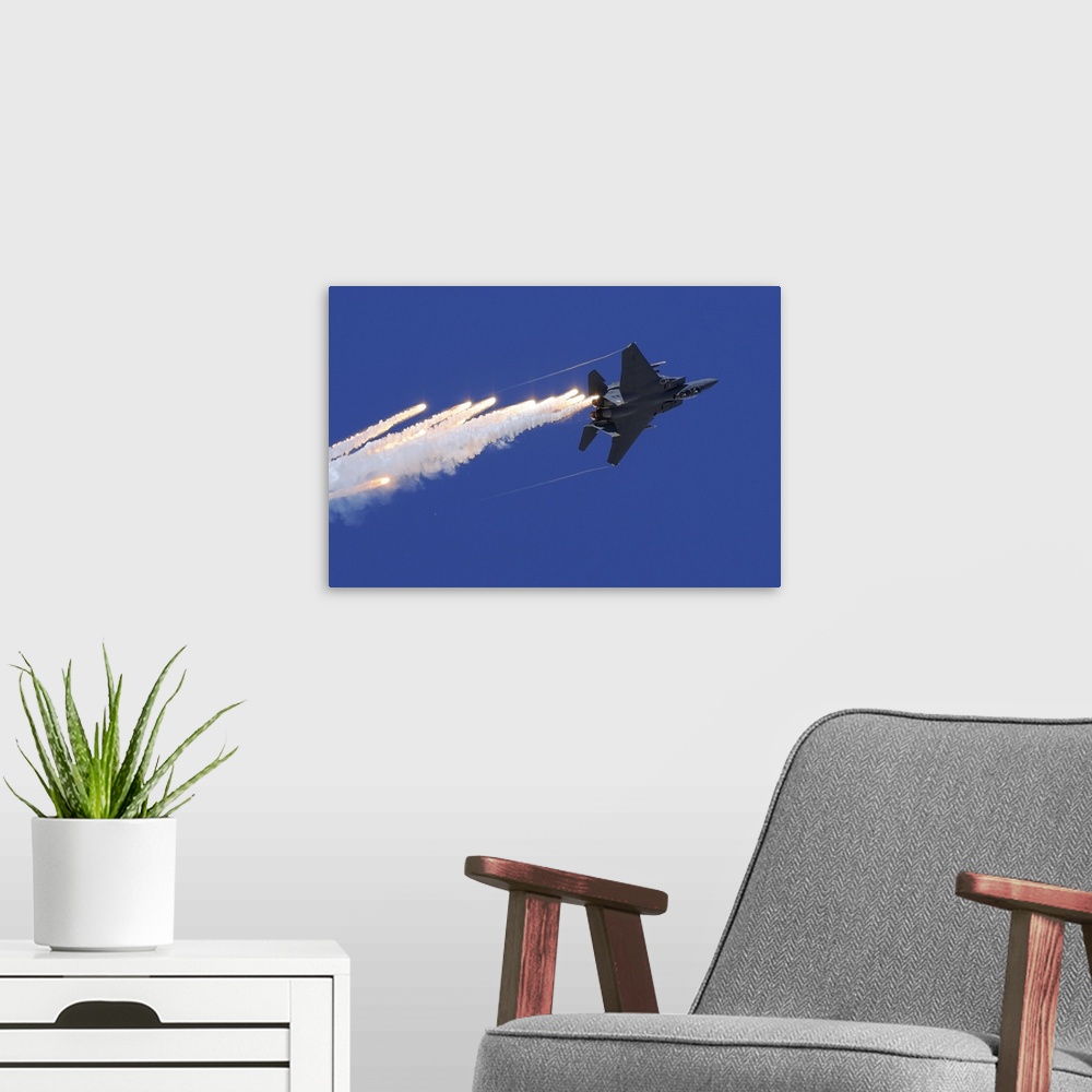 A modern room featuring November 11, 2012 - An F-15E Strike Eagle releases flares above Nellis Air Force Base, Nevada.