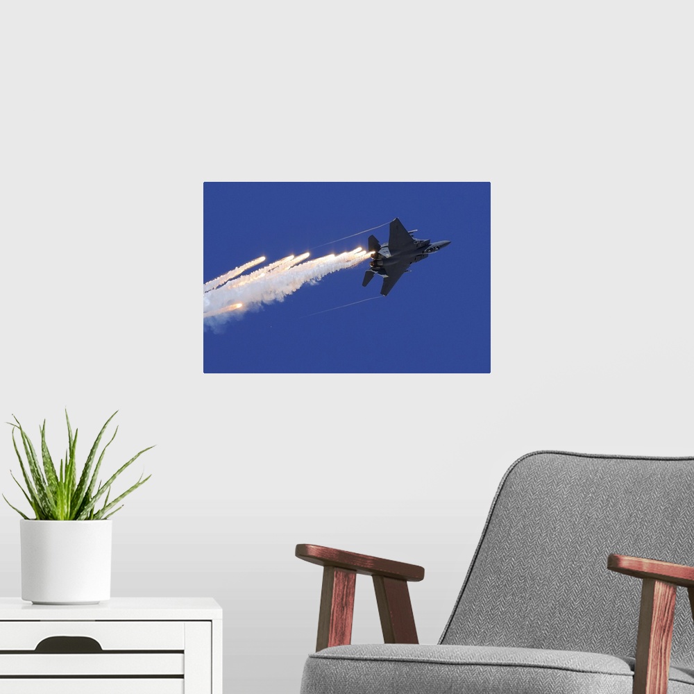 A modern room featuring November 11, 2012 - An F-15E Strike Eagle releases flares above Nellis Air Force Base, Nevada.