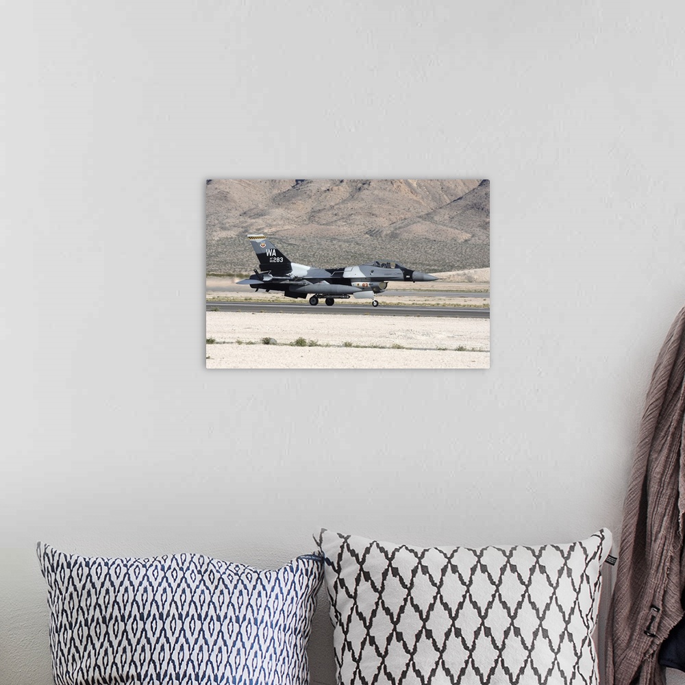 A bohemian room featuring An F-16C Aggressor jet landing on runway in Nevada.