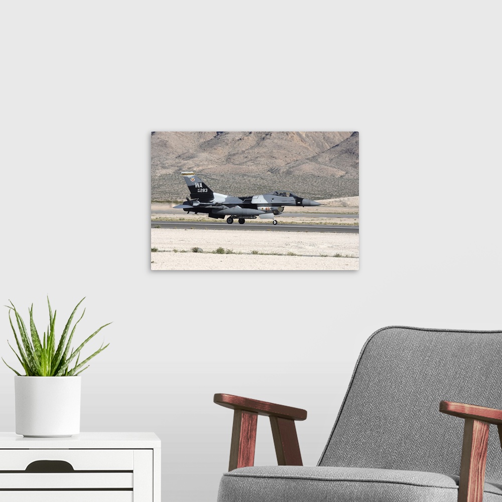 A modern room featuring An F-16C Aggressor jet landing on runway in Nevada.