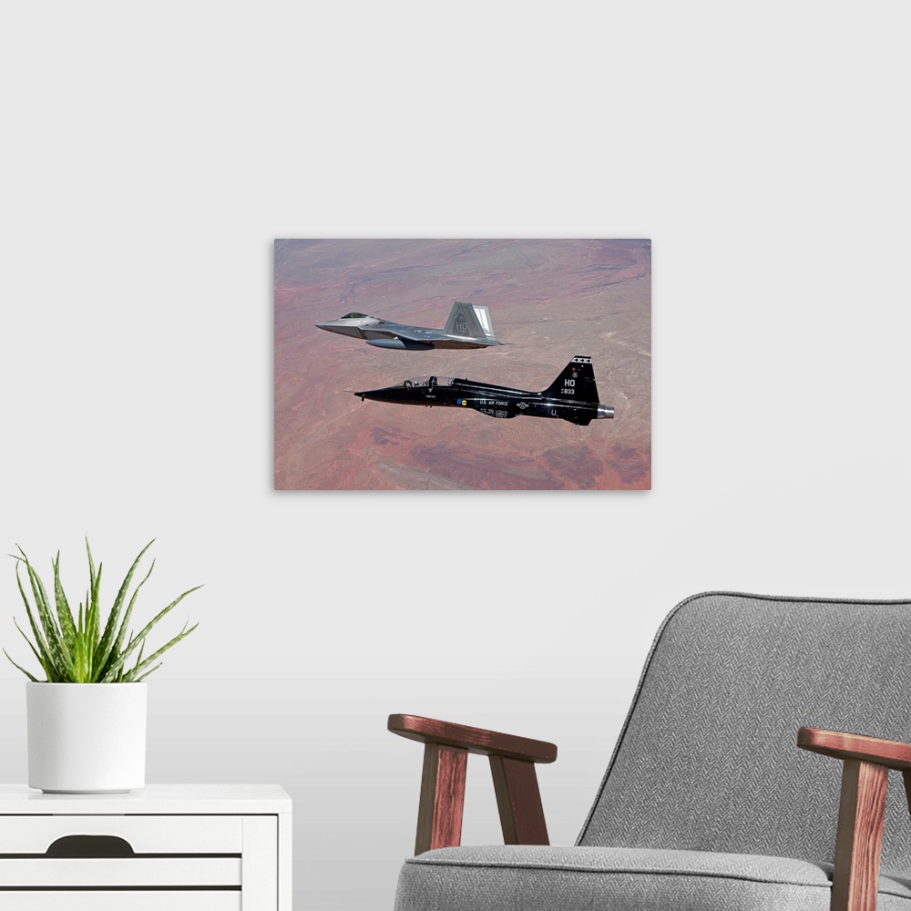 A modern room featuring An F-22 Raptor from the 49th Fighter Wing flies in formation with a T-38 Talon while on a trainin...