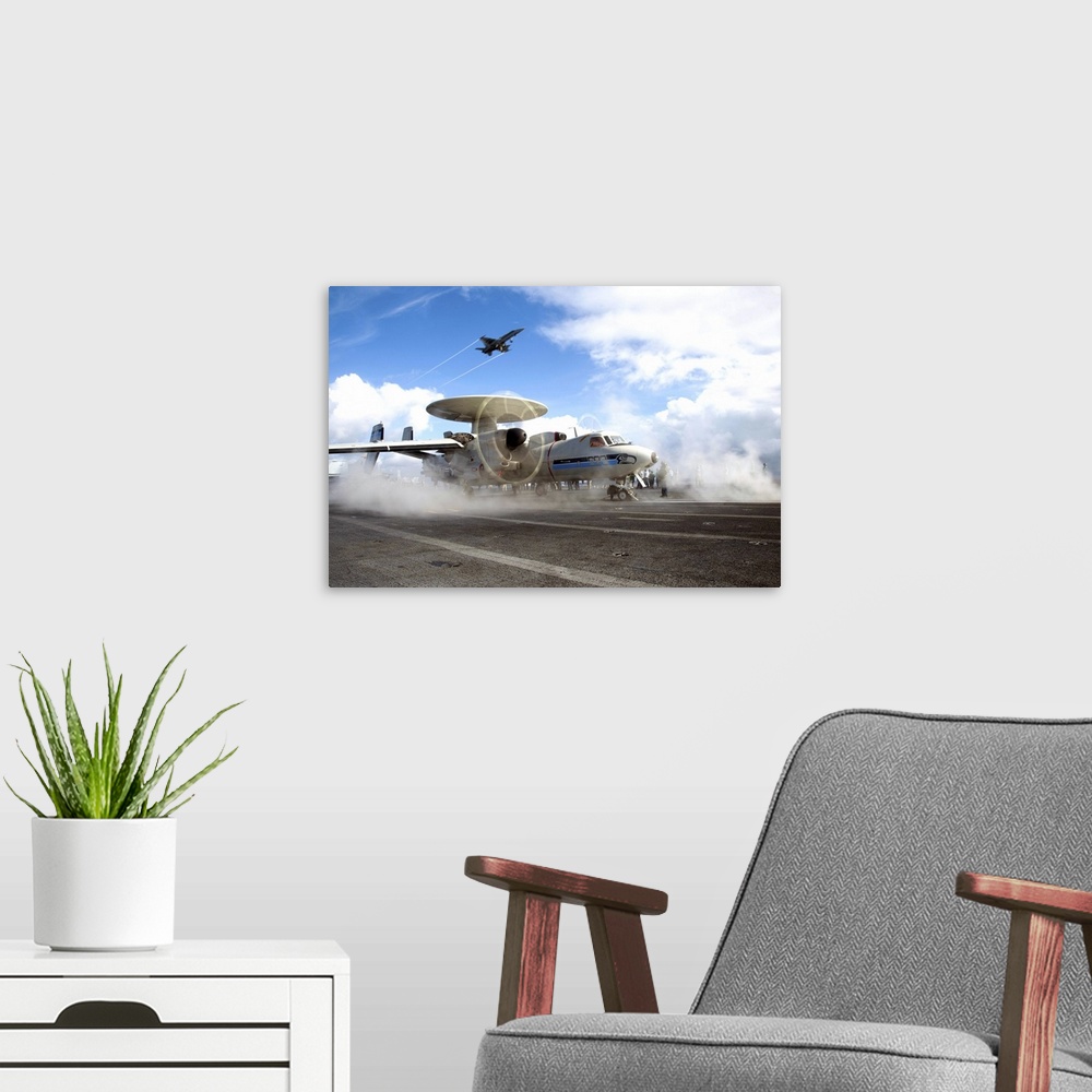 A modern room featuring Atlantic Ocean, January 16, 2013 - An F/A-18C Hornet flies overhead as an E-2C Hawkeye prepares t...