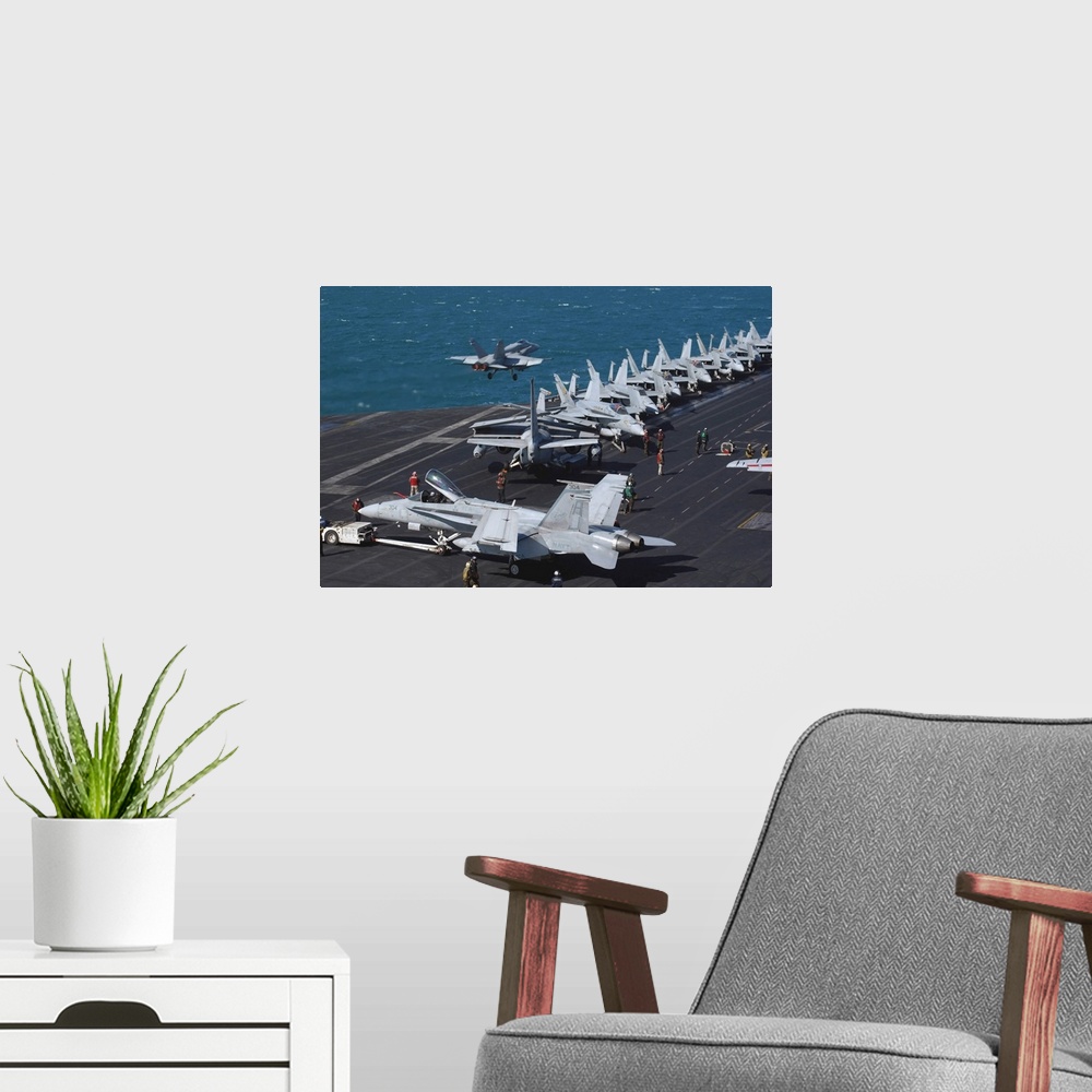 A modern room featuring An F/A-18C Hornet launches from the flight deck aboard USS Theodore Roosevelt.