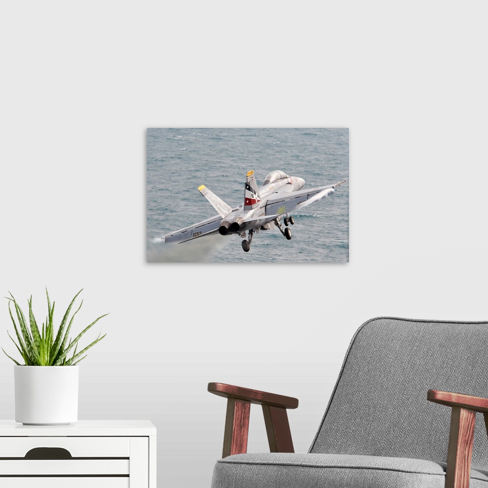 A modern room featuring An F/A-18F Super Hornet launches from USS Abraham Lincoln.