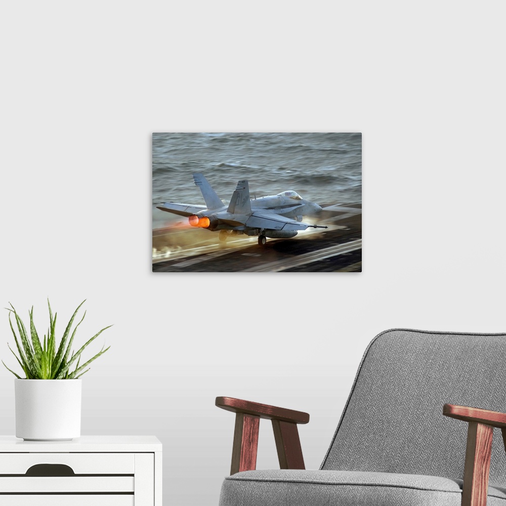 A modern room featuring Up-close photograph of jet taking off of an air craft carrier in the ocean.