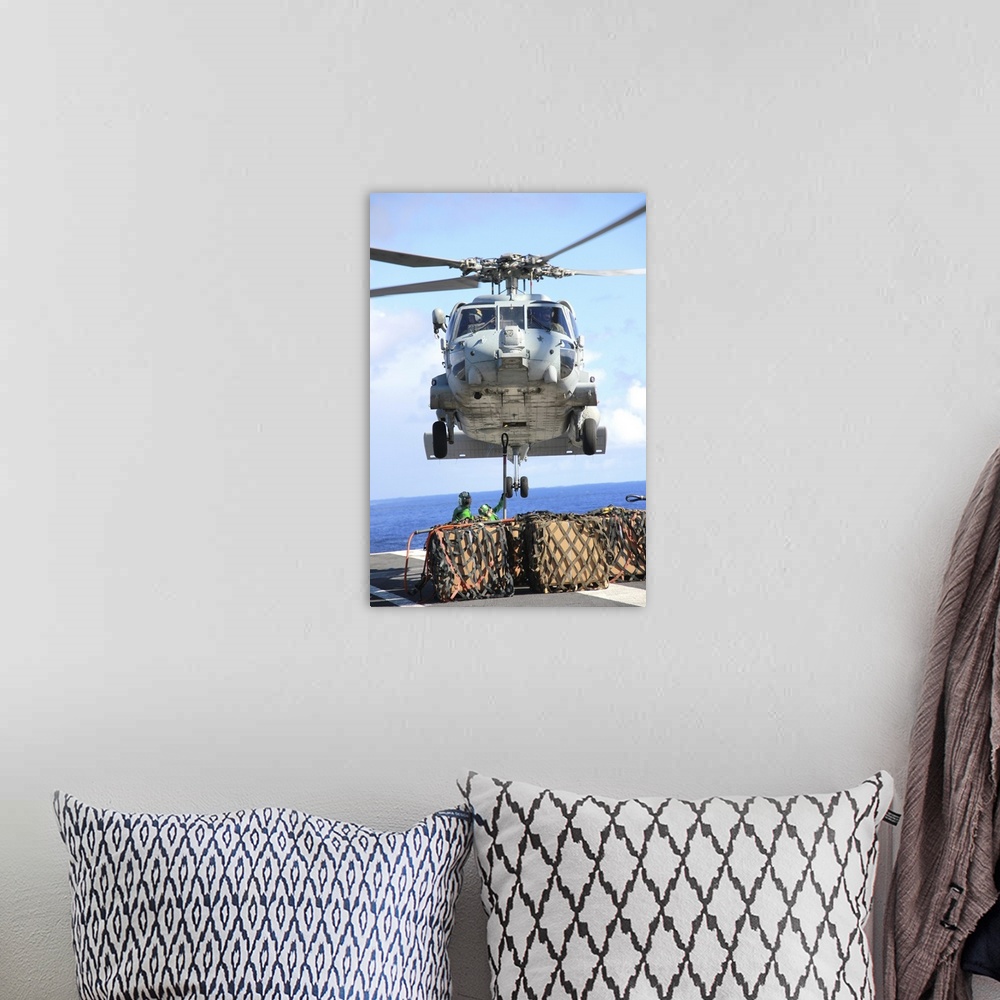 A bohemian room featuring An HH-60H Sea Hawk helicopter picks up supplies from the flight deck.