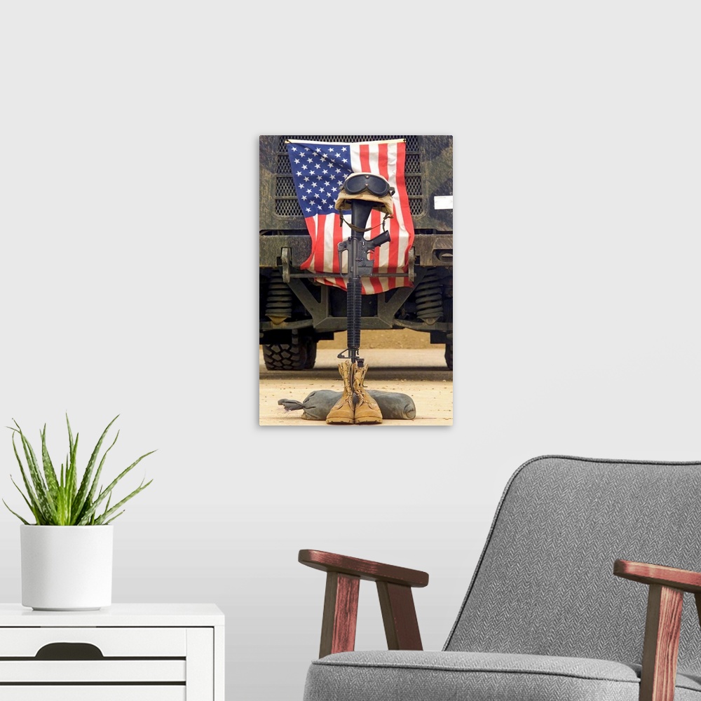 A modern room featuring Tall photo on canvas of a rifle sticking out of two boots with a helmet on top in front of an Ame...
