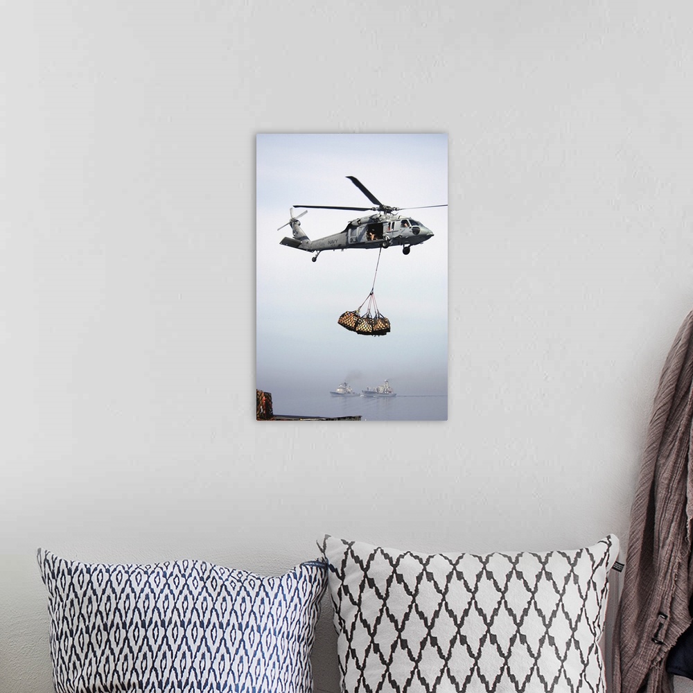 A bohemian room featuring An MH-60S Knighthawk delivering cargo.