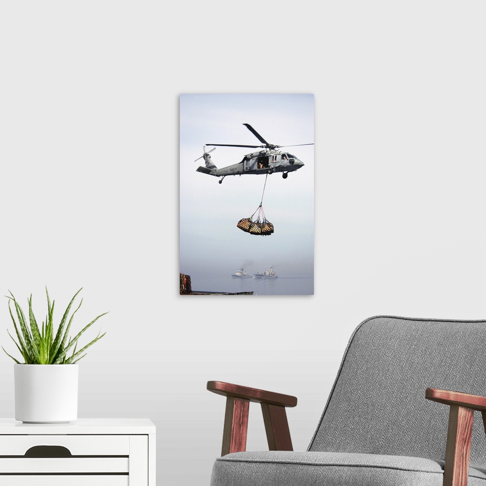 A modern room featuring An MH-60S Knighthawk delivering cargo.
