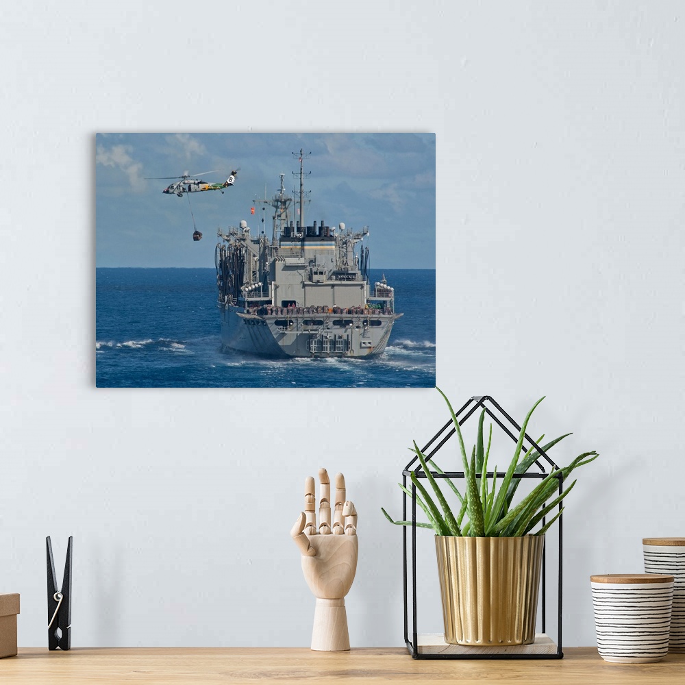 A bohemian room featuring An MH-60S Sea Hawk conducts a vertical replenishment with USNS Bridge.
