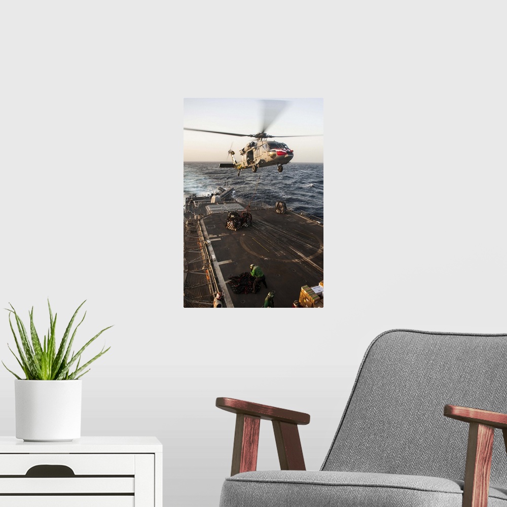 A modern room featuring February 16, 2013 - An MH-60S Sea Hawk helicopter delivers cargo to the Ticonderoga-class guided-...