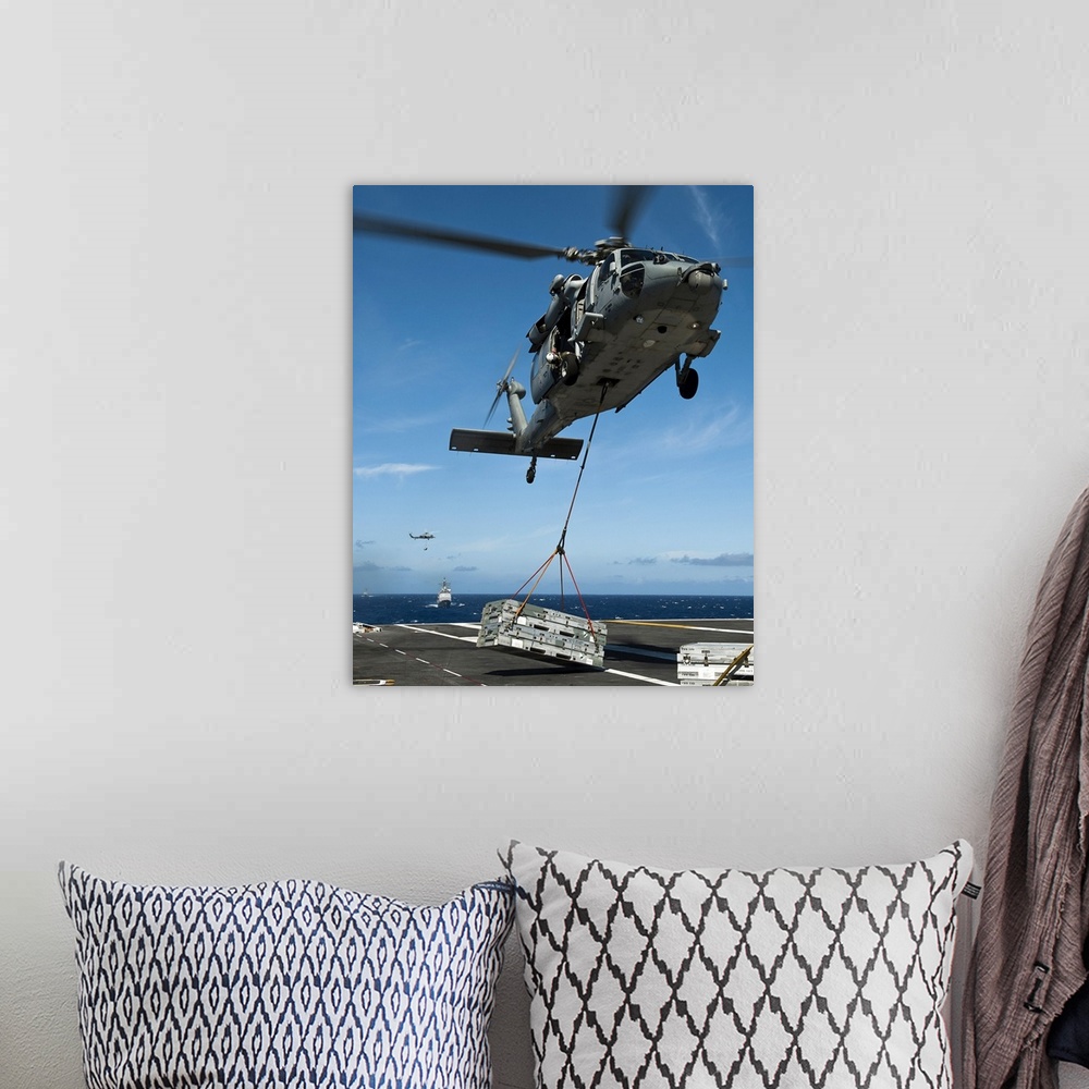 A bohemian room featuring Pacific Ocean, August 7, 2011 - An MH-60S Sea Hawk helicopter lowers cargo onto the deck of the N...